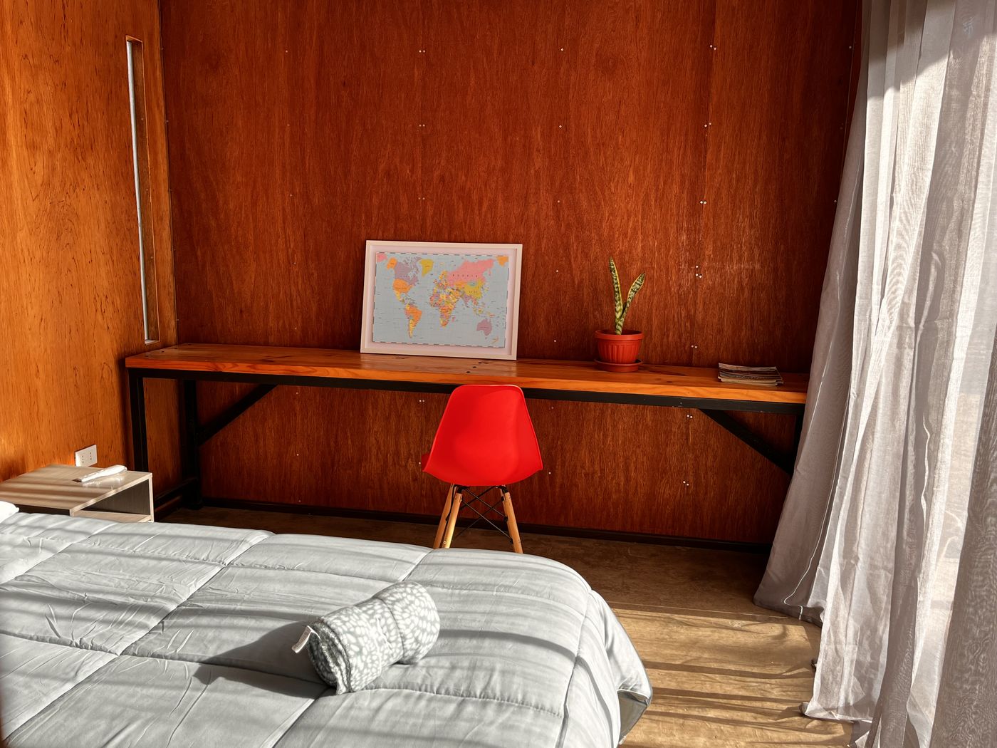 Escritorio con mapamundi y silla roja en la habitación