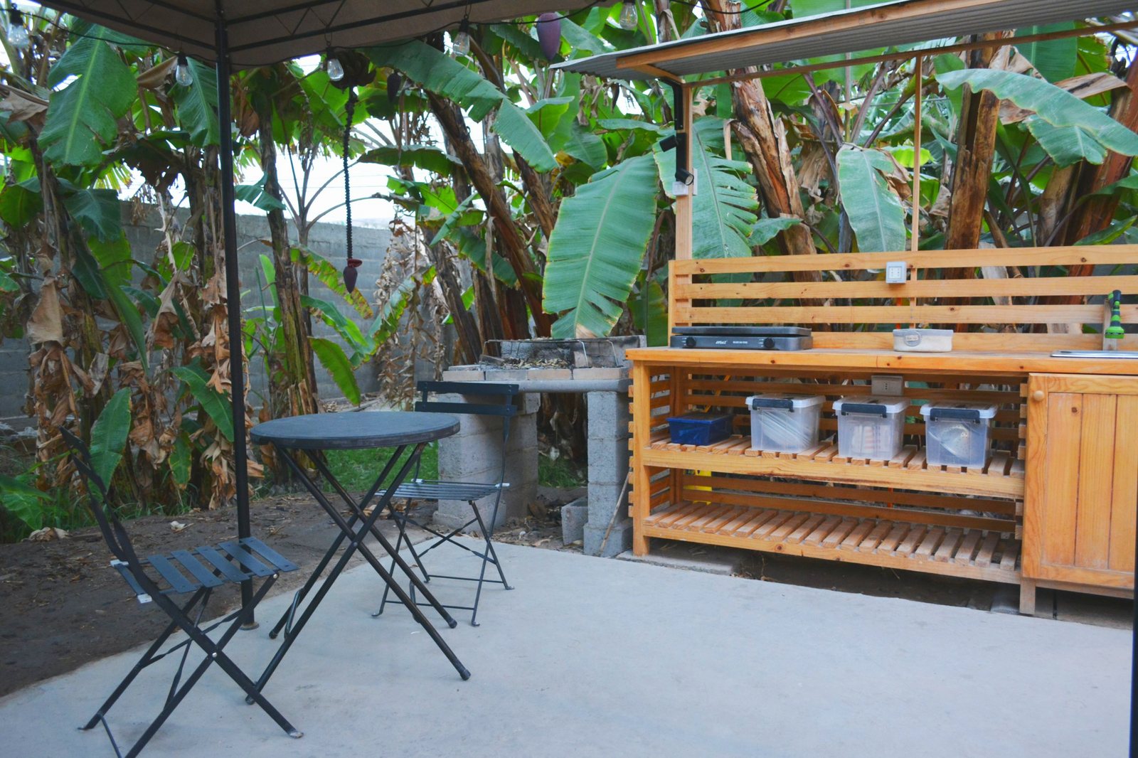 Cocina exterior bajo el gazebo entre los platanares