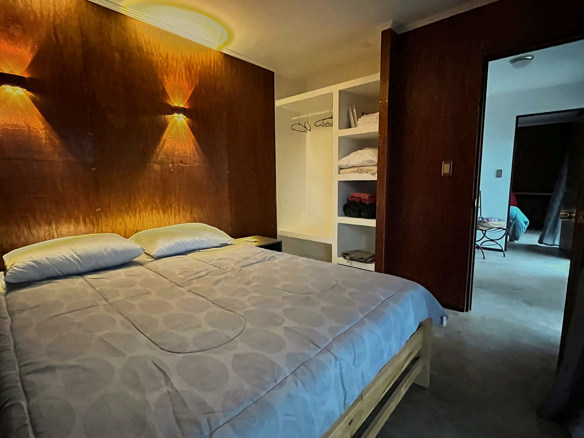 Dormitorio con cama matrimonial, luz cálida y closet